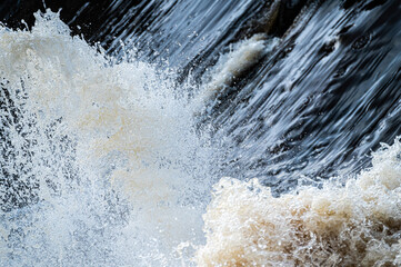 close up of flowing water, rapid water splashes of an white water river or stream, bubbly water
