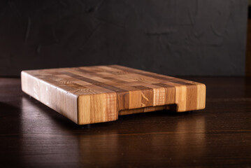 Wooden cutting board on dark background