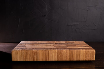 Wooden cutting board on dark background