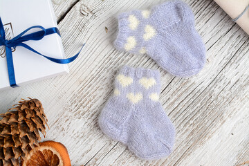 colorful and small baby socks, made of cotton yarn, on vintage white wooden background