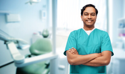 healthcare, profession and medicine concept - happy smiling doctor, dentist or male nurse in blue...
