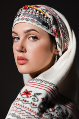 portrait of young ukrainian woman in traditional headwear posing isolated on black.