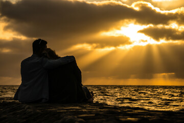 Silhouette of Happy Young Couple love Outside at Sunset. happy man and woman silhouette embracing in sunlight evening sky in the ocean. wedding couple hugging in dusk sun light, romantic moment