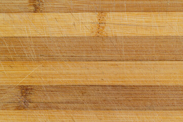 Tagliere in bambù da cucina marrone chiaro usato con righe orizzontali, vista superiore, macro