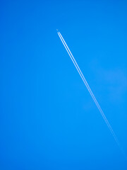 Airplane flying in sky. White lane. Blue sky.