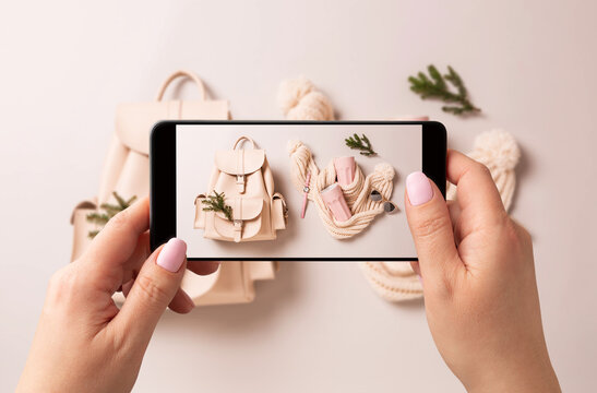 Woman taking photo of winter fashion accessories (Christmas gifts) with smartphone - social media
