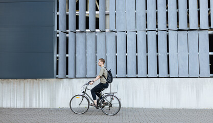 Young man riding a bike. Sustainable micro mobility transport New way of inclusive cities mobility....