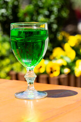 close-up Green lemonade Tarragon in a glass glass on a blurry background. Green drink from healthy herbs Tarragon