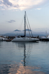 Fototapeta premium Sailboat in harbor on a summer evening with Mount Vesuvius in the background, Naples, Italy