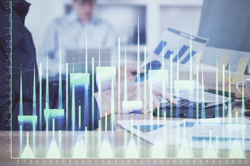 Double exposure of graph with man typing on computer in office on background. Concept of hard work. Closeup.