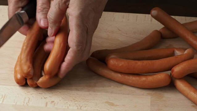 Thin pork sausages on the wooden cutting board