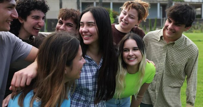 Young group of friends having fun outdoor with university on background 