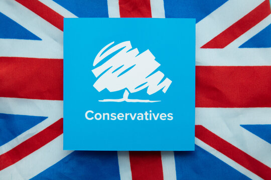 LONDON, UK - July 2022: Conservative United Kingdom political party logo on a union jack flag