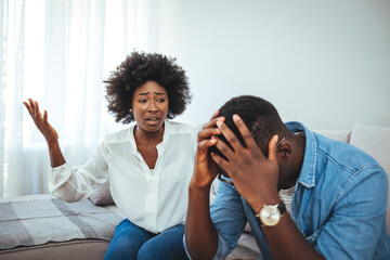 Emotional annoyed stressed couple sitting on couch, arguing at home. Angry irritated nervous woman man shouting at each other - obrazy, fototapety, plakaty