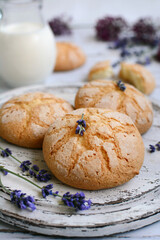 vertical composition. Homemade biscuit cookies on a white wooden plate with lavender sprigs. Closeup