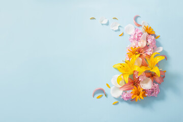 Fototapeta na wymiar beautiful summer flowers on blue paper background