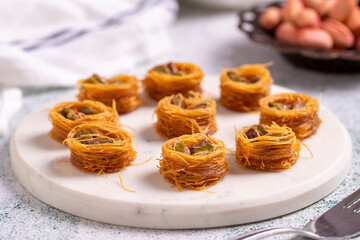 Bulbul Kadayif with Pistachio. Kadayif baklava with pistachio filling on a stone floor. Turkish cuisine desserts. Close-up. local name Antep Fıstıklı Bülbül Kadayıf
