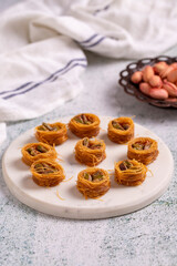 Bulbul Kadayif with Pistachio. Kadayif baklava with pistachio filling on a stone floor. Turkish cuisine desserts. Close-up. local name Antep Fıstıklı Bülbül Kadayıf