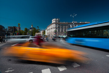 Long exposure photo of traffic. Bus and taxi at the crossroads.