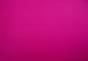 Abstract background made of corrugated paper for pink application. Space for text. Texture. Vertical stripes.