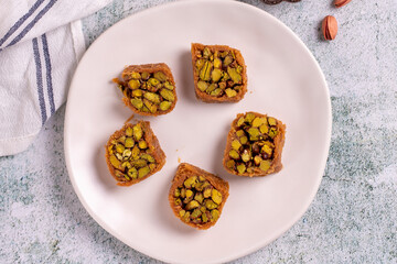 Pistachio kadayif dessert. Kadayif baklava with pistachio filling on a stone floor. Turkish cuisine desserts. Close-up. local name fıstıklı kadayif