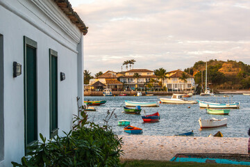 Typical colonial house next to the beach with small fishing boats, in the Passage neighborhood, Cabo Frio, Brazil.