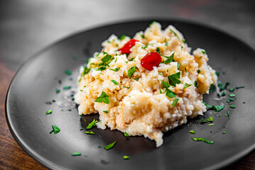 Risotto in a black plate on wooden background