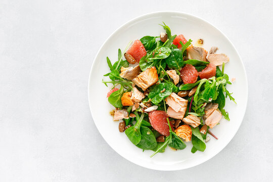 Grilled salmon salad with grapefruit, almonds and salad mix. Top view