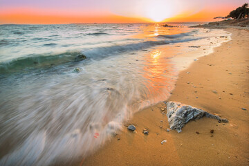 Sunset long exposure shot landscape on the beach with stones and reflection