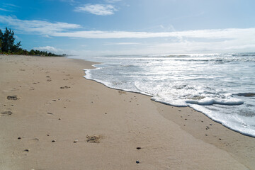 Waves lapping on the sands of the empty beach.