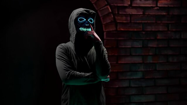 A brooding woman with a death mask, wearing a hoodie with a hood. The concept of the Day of the Dead or Halloween.