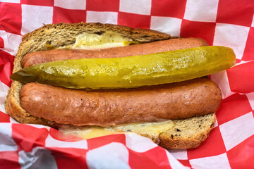 Hot dogs on rye bread with pickle and melted cheese..