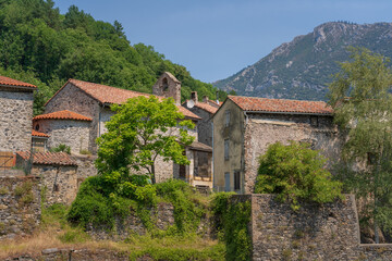 Fototapeta na wymiar Scenic summer landscape of traditional rural mountain village with ancient church in the French Pyrenees, Gincla, Aude, France 