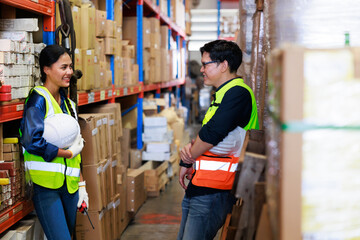 Portrait Asian male and female warehouse worker checking order stock. Professional industrial warehouse team working at store workplace. Unity and teamwork concept.