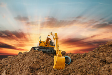 Excavator is digging in the construction site pipeline work ,on a sunbeam background .