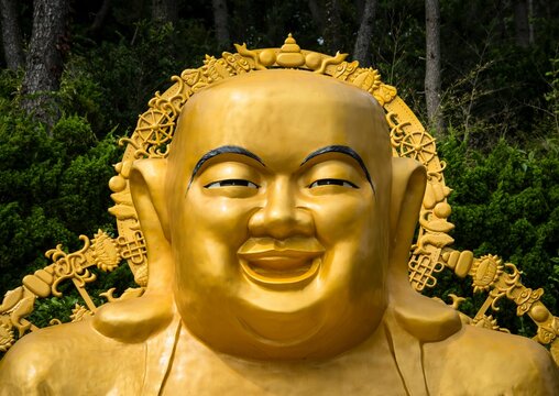 Closeup shot of the gead of a happy golden Buddha in Paochueh Temple in Taichung, Taiwan
