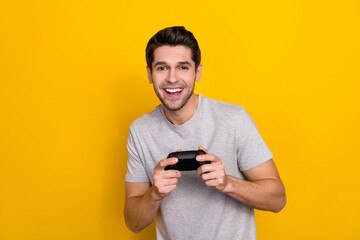 Photo of nice brunet millennial guy playstation wear grey t-shirt isolated on yellow color background