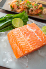 Salmon fillet. Fresh raw salmon is placed on ice with a slice of lemon next to it.