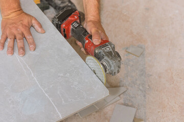 Angle grinder polishing disk with diamond is used by the worker for polishing the cut corner tiles with the angle grinder