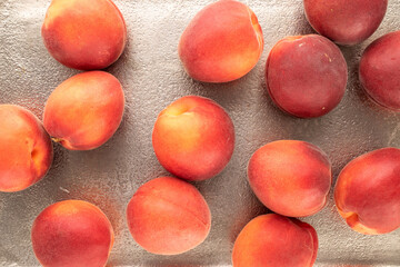Several organic red apricots on a metal dish, close-up, top view.