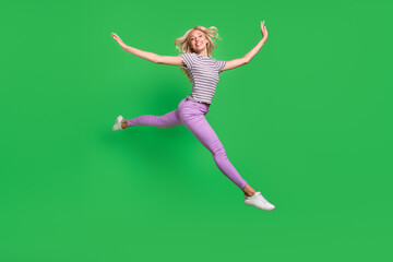 Fototapeta na wymiar Full body portrait of sporty excited cheerful girl jumping rush hurry isolated on green color background