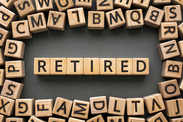 Inscription Retired software development concept. Wooden cubes with letters scattered blurred background