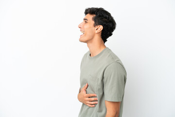 Young Argentinian man isolated on white background laughing in lateral position