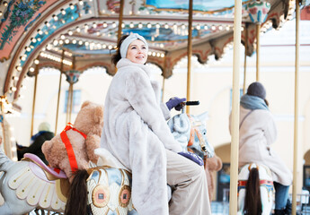 Charming woman rides a carousel and has fun