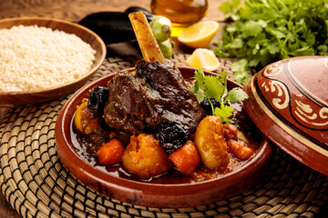 Moroccan lamb and Vegetables Tangine with bread served in a dish isolated on wooden background side...