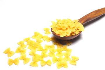 Raw pasta farfalle on wooden spoon on White background. Top view of Italian cuisine ingredient.