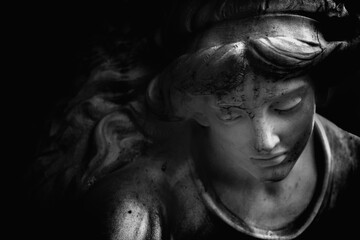 Fragment of an ancient statue of guardian angel. Black and white image.