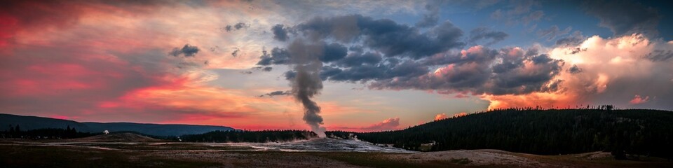 Panoramic view of Old Faithful Geyser at colorful sunset in Yellowstone National Park, Wyoming - obrazy, fototapety, plakaty