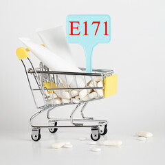 Titanium dioxide, E171, dangerous additive concept. gum, pills, toothpaste, cream in basket and sign with E171 on white background. copy space square