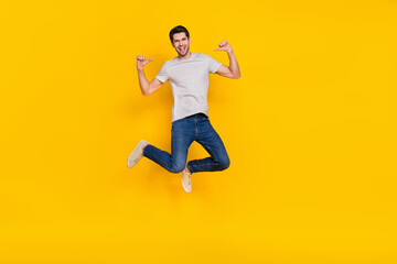 Fototapeta na wymiar Full length body size view of attractive cheerful guy jumping demonstrating himself isolated over bright yellow color background